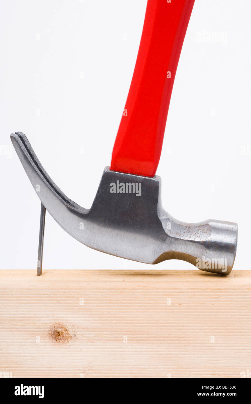 Using a claw hammer to remove a nail from timber Stock Photo