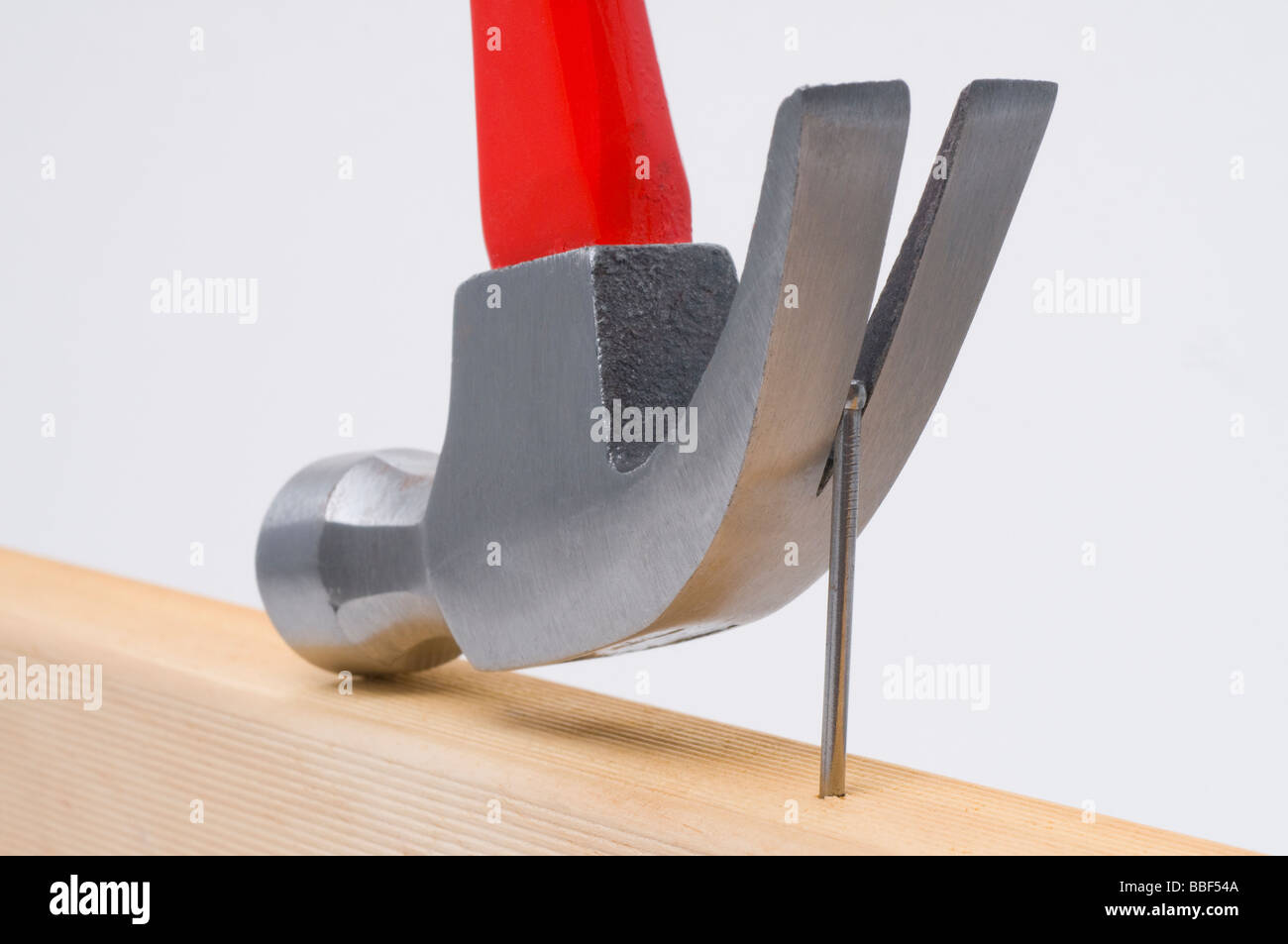 Using a claw hammer to remove a nail from timber Stock Photo
