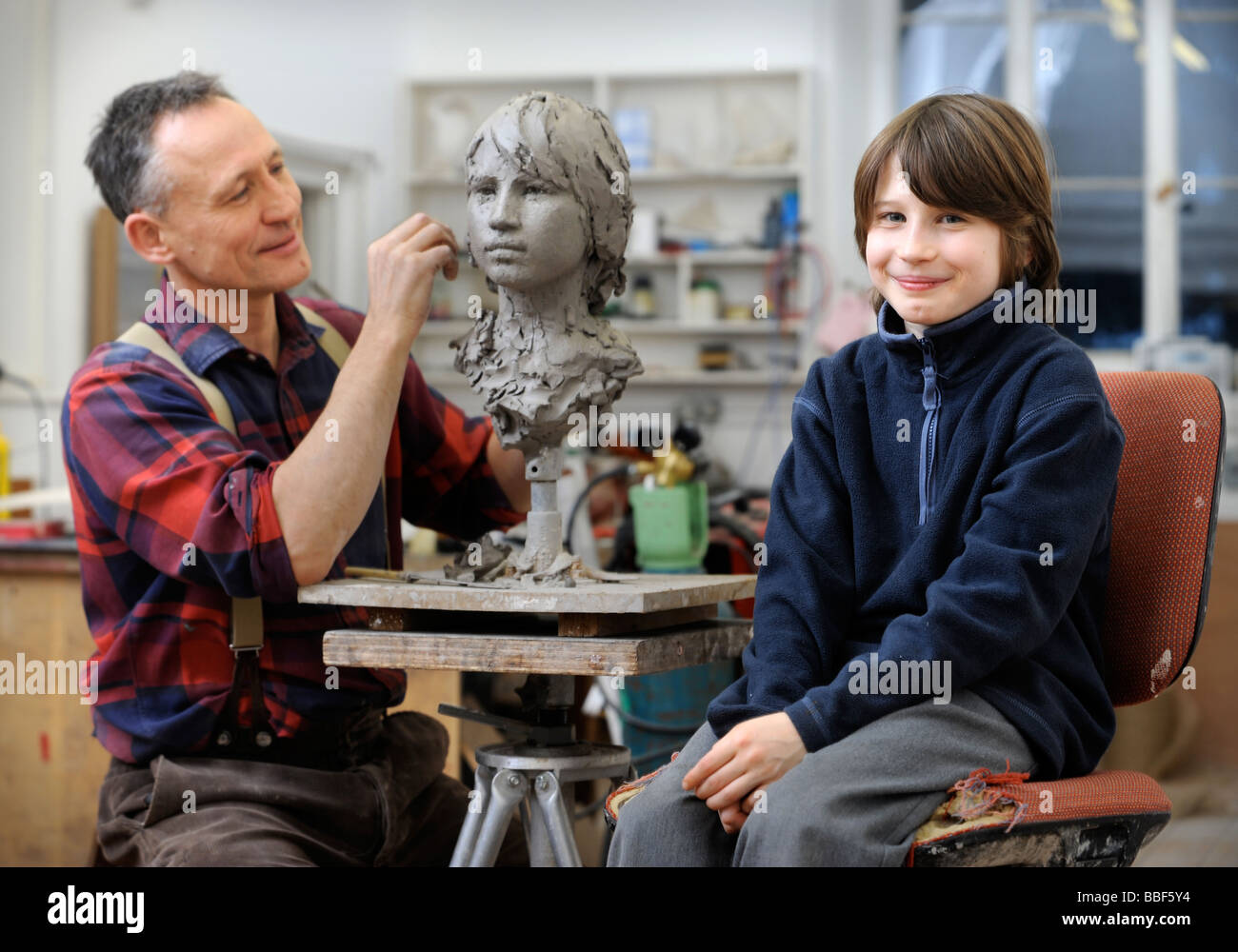 Sculptor Mark Richards in his studio near Ludlow working on a clay head of his son Gil 2008 Stock Photo