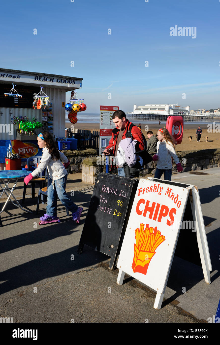 VISITORS ON THE FRONT IN EARLY SPRING SUNSHINE AT WESTON SUPER MARE SOMERSET UK Stock Photo