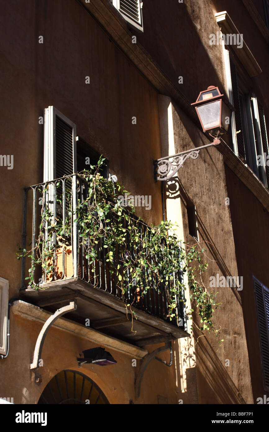 Window with balcony, shutters and street lamp, Rome. Stock Photo