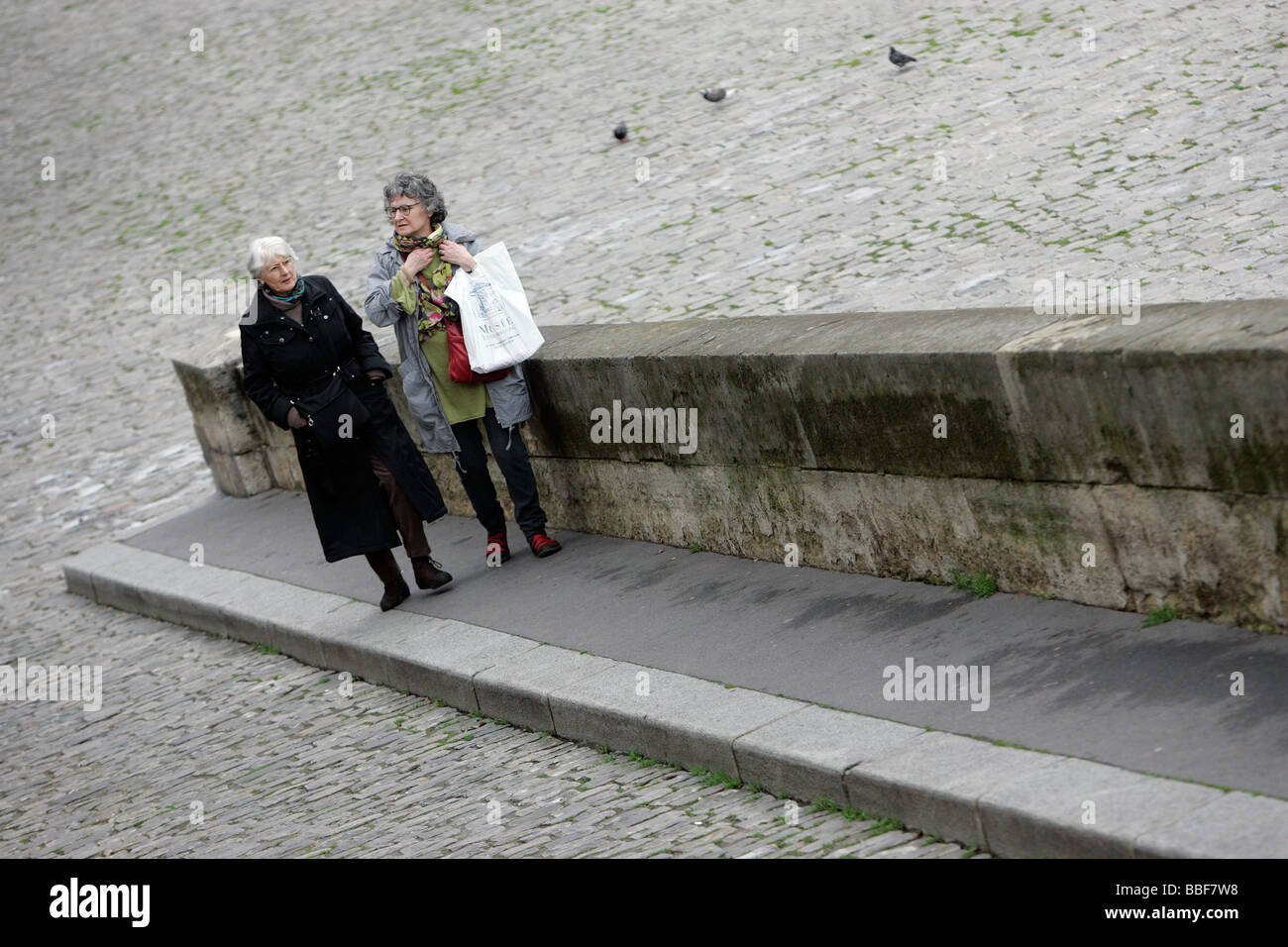 Two woman stroll on the quai along the Seine, Paris Stock Photo