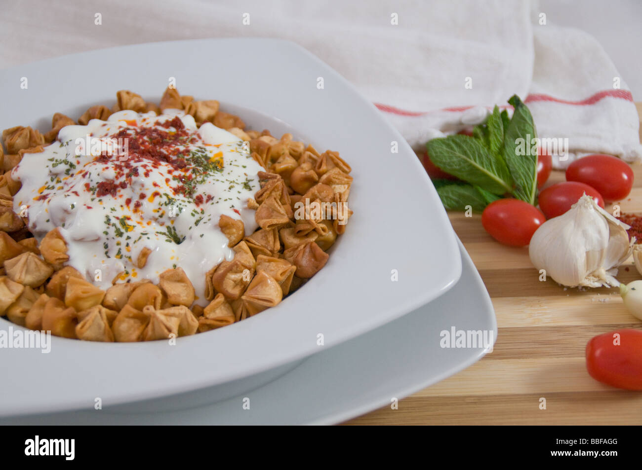 Turkish cuisine, manti (dumplings), fried and served with yogurt, mint and chilli peper Stock Photo
