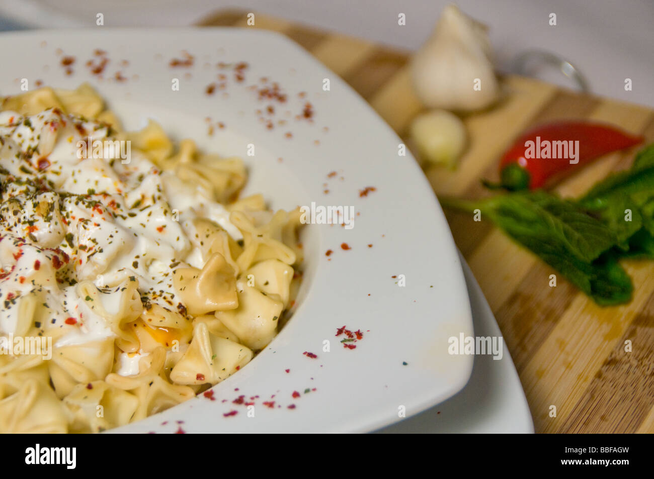 Turkish cuisine, manti (dumplings), boiled and served with yogurt, mint and chilli peper Stock Photo