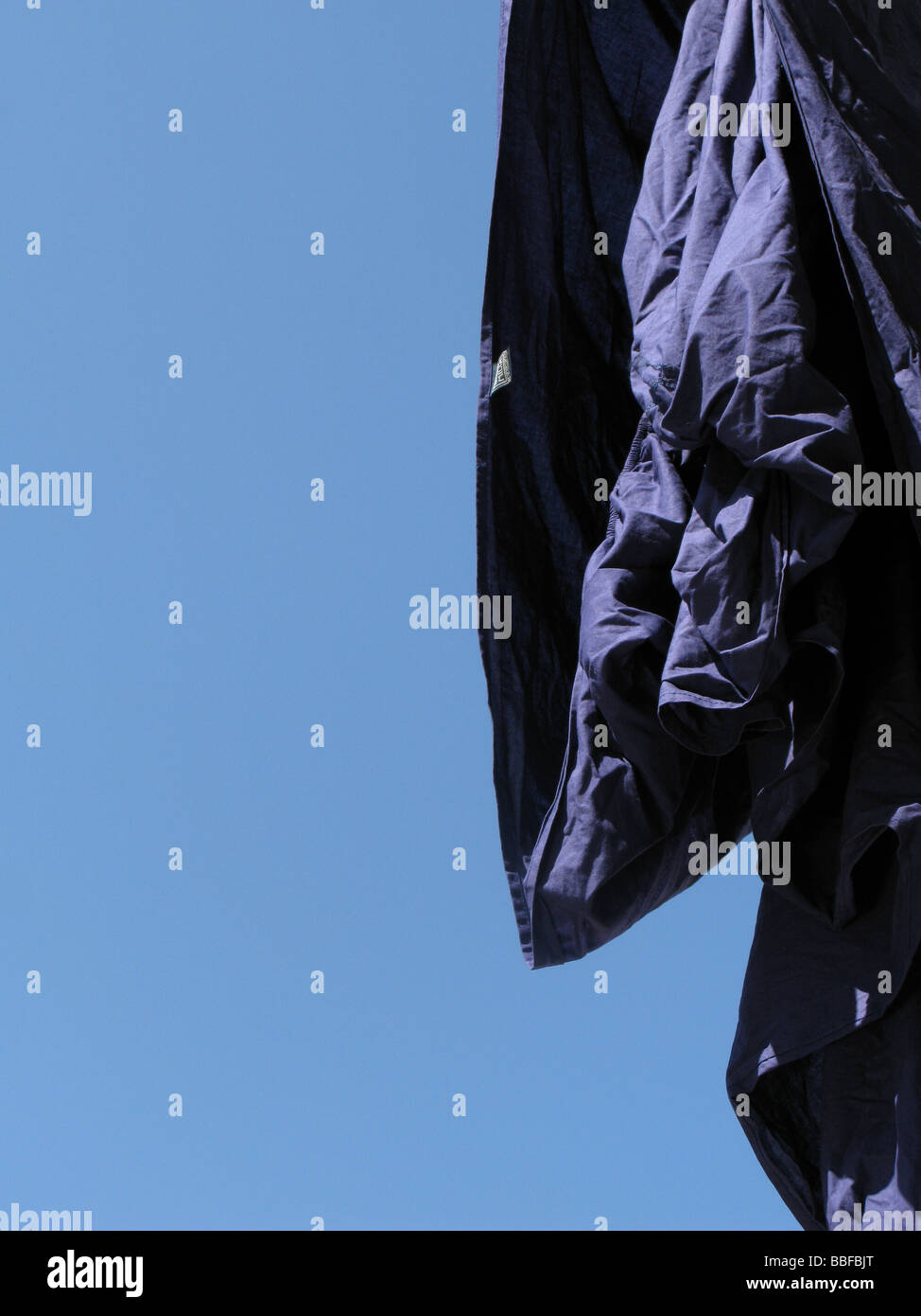 one blue bed sheet hanging on washing line in sun Stock Photo Alamy