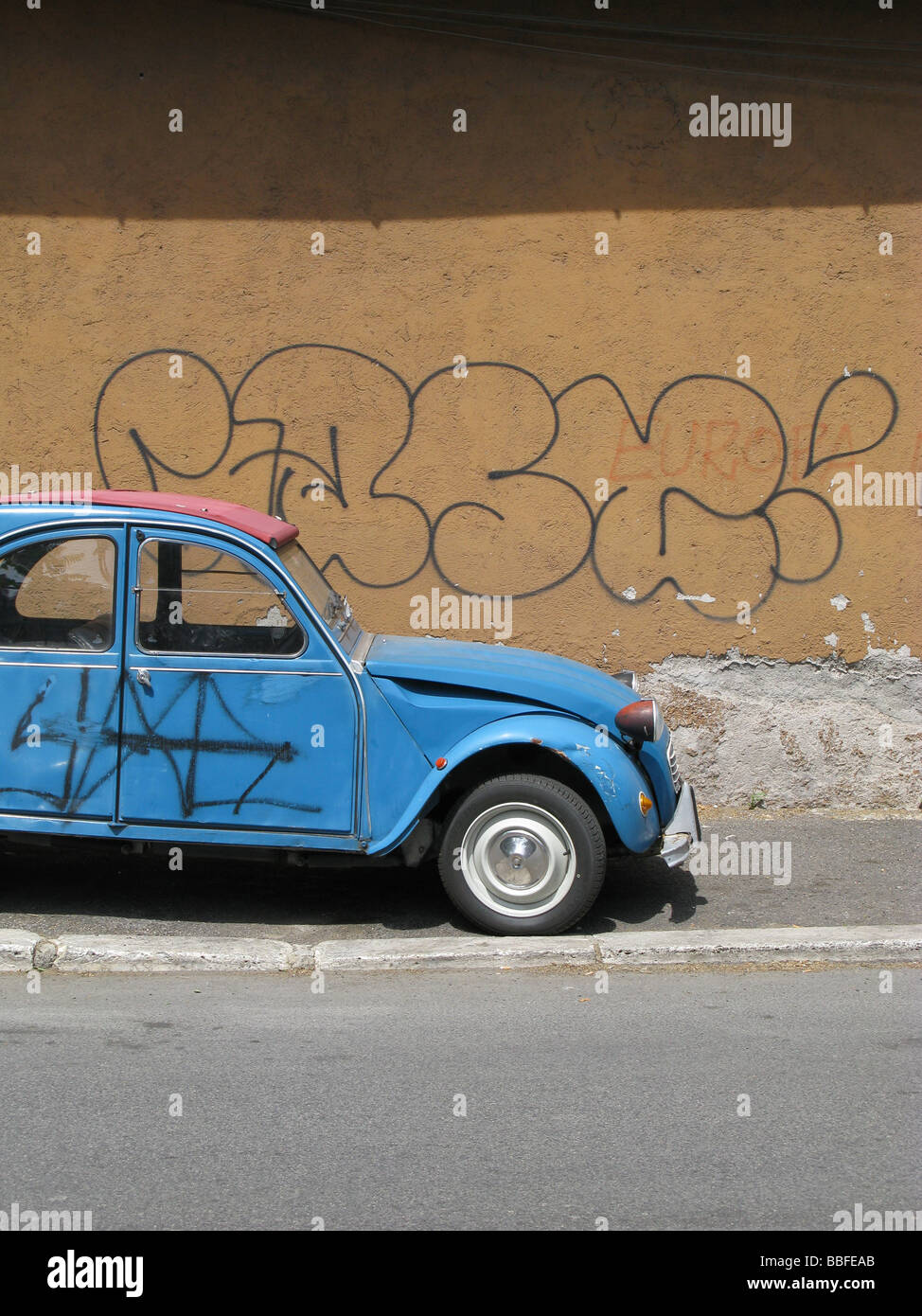 one citroen 2cv covered with graffiti in street in city town Stock Photo