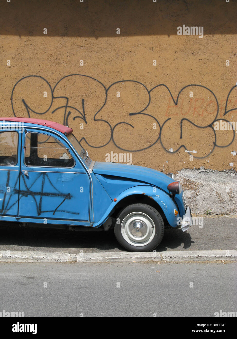 one citroen 2cv covered with graffiti in street in city town Stock Photo