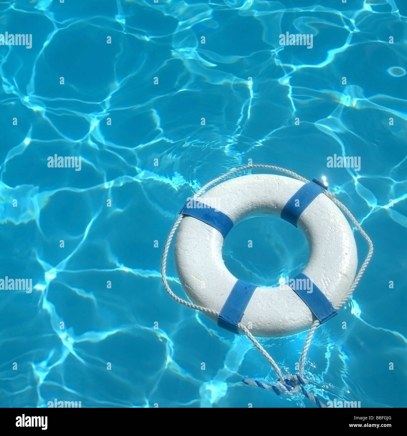 Life ring floating on top of sunny blue water Stock Photo