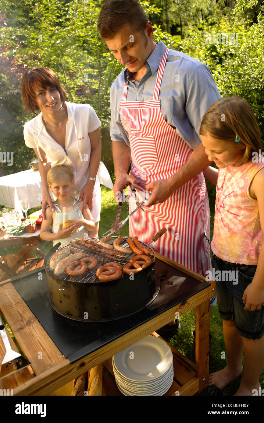 Family Enjoying Barbecue In The Garden Stock Photo - Alamy