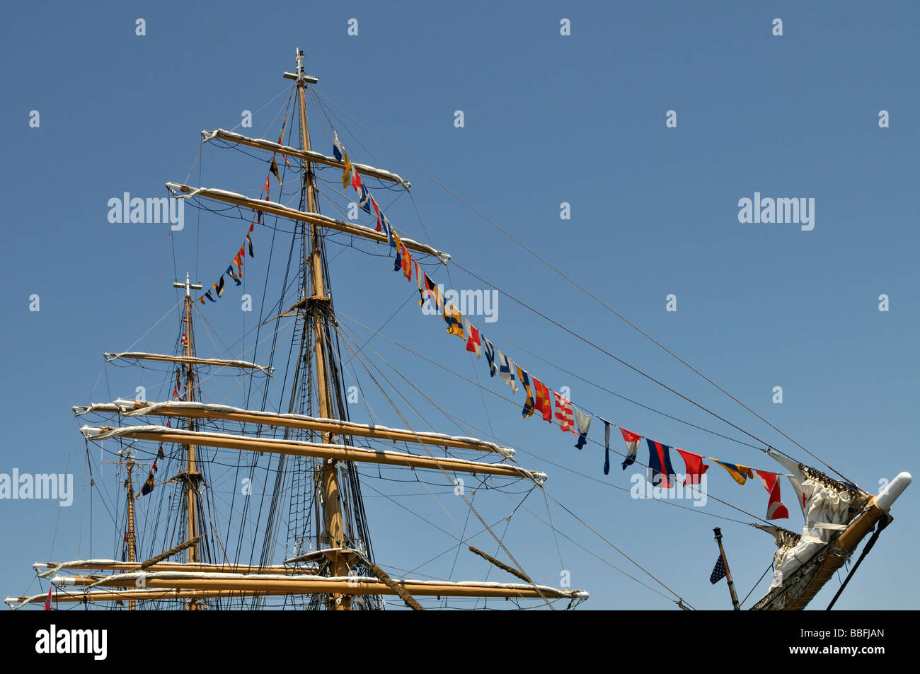 Part of bow and tops of masts of the USCG Barque Eagle docked along the main channel of Port of Los Angeles Stock Photo
