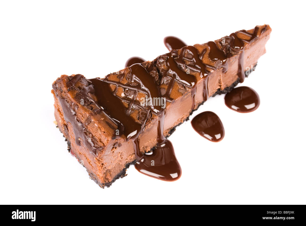 A slice of sweet chocolate cheesecake with chocolate syrup isolated on white Stock Photo