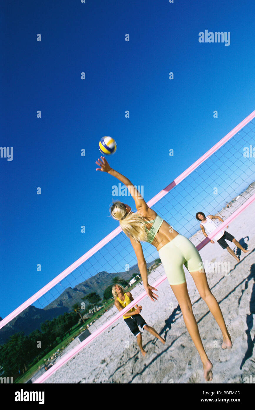 Female jumping to hit volleyball over net Stock Photo Alamy