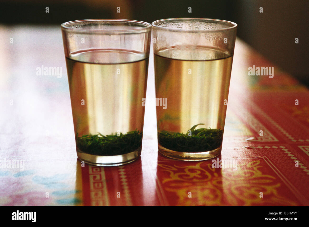 Two glasses of tea with tea leaves steeping Stock Photo