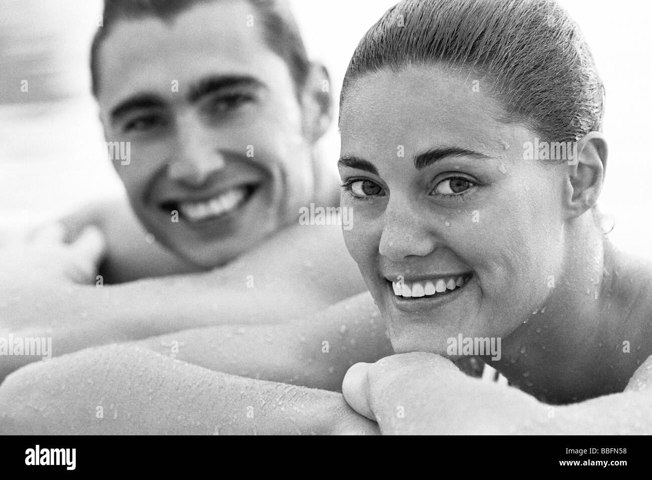 Young couple resting heads on arms, wet, portrait Stock Photo