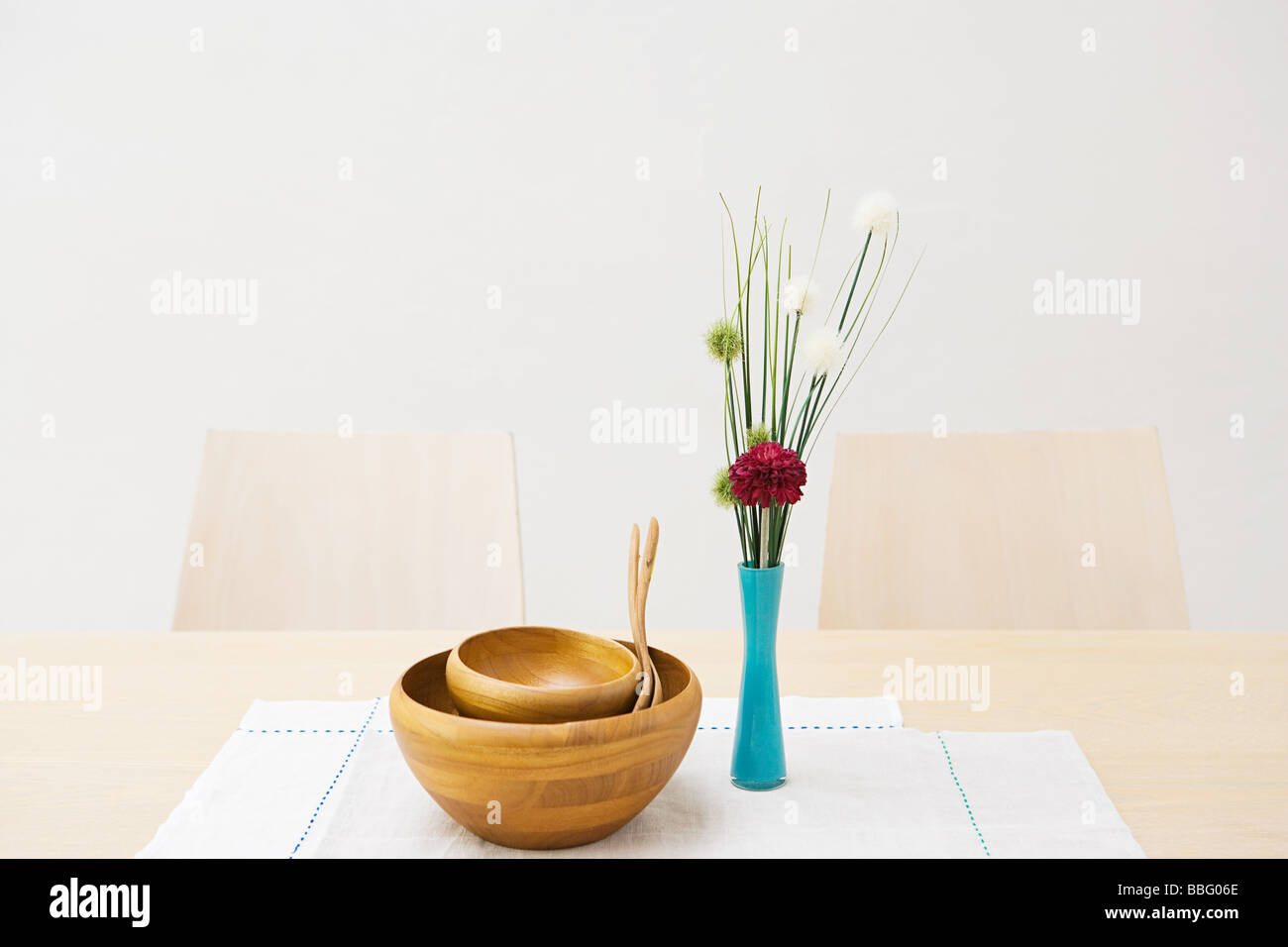 Vase of flowers and bowls on a table Stock Photo