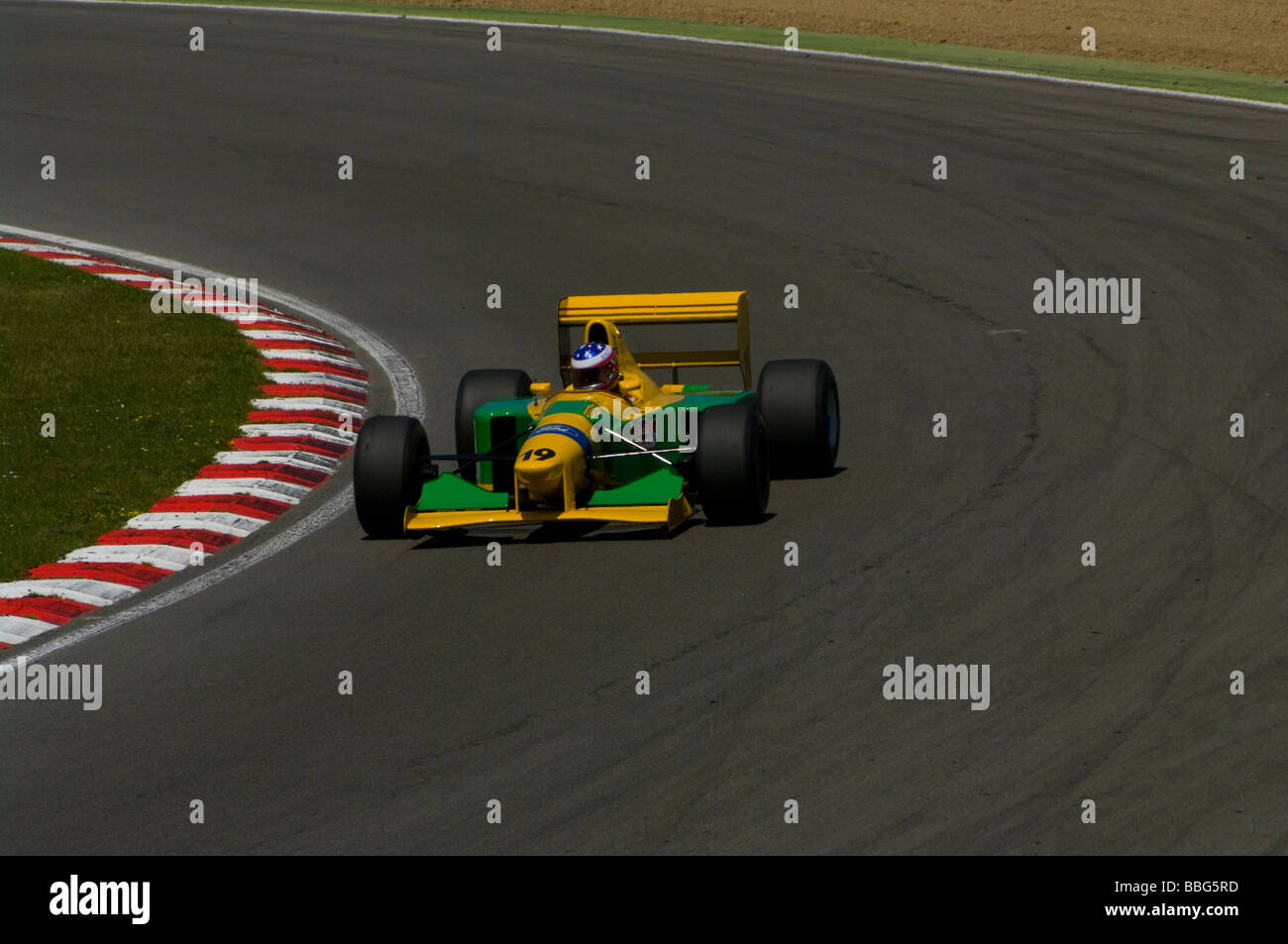 Yellow and Green Benetton Formula 1 Racing Car driven by Patrick D Aubreby  Rounding Paddock Hill Bend Brands Hatch Kent England Stock Photo - Alamy