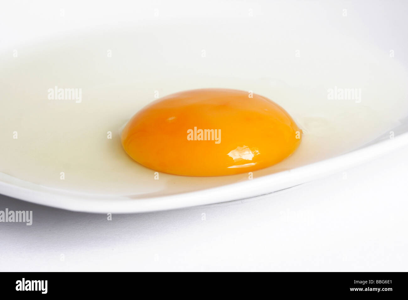 Raw egg on a plate, egg yolk Stock Photo Alamy