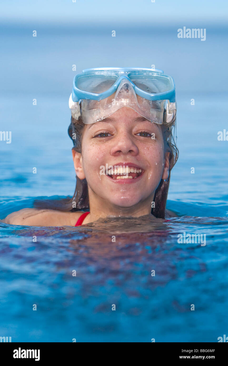 Girl with diving goggles in a swimming pool, laughing into the camera Stock Photo