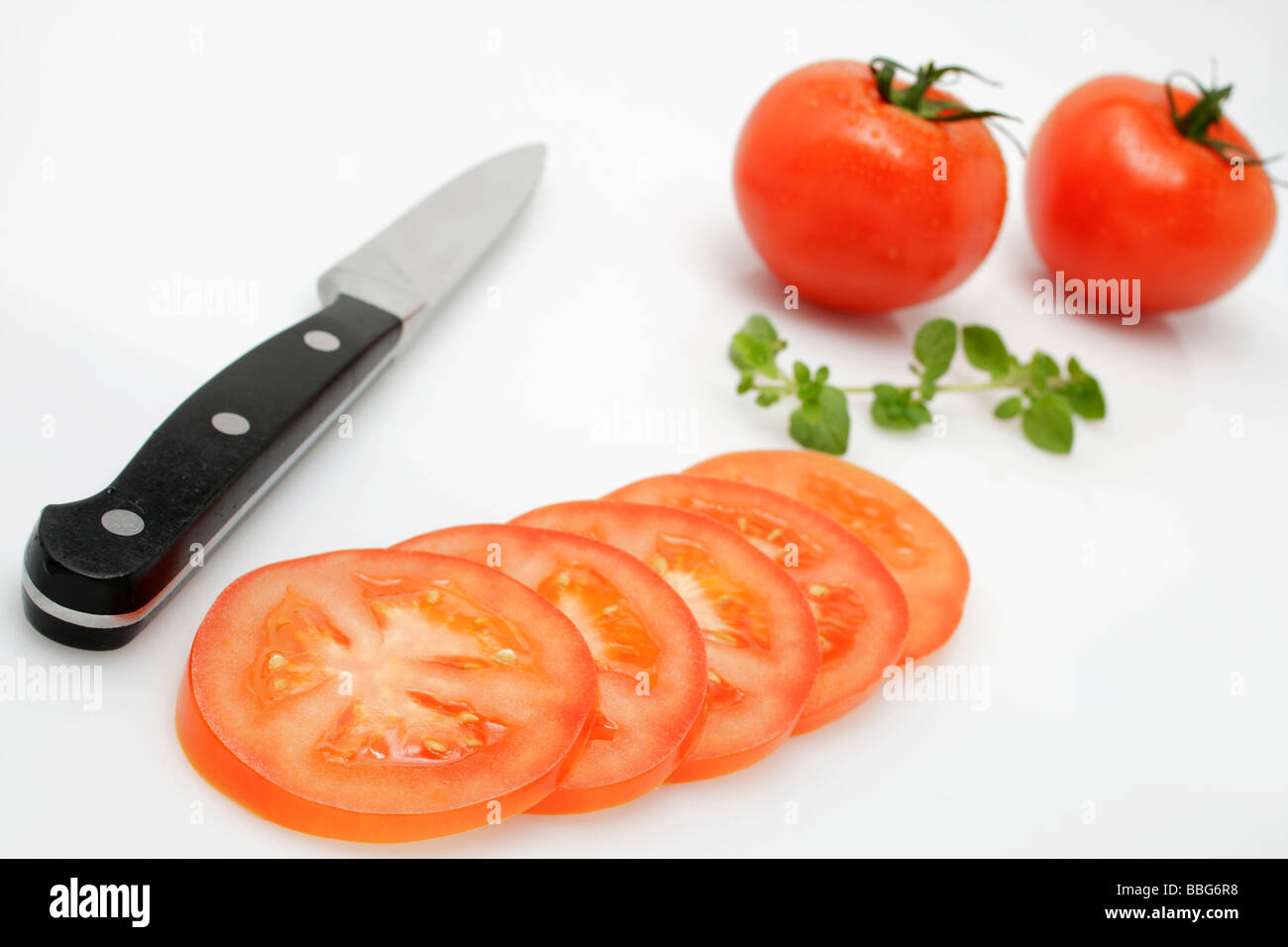 Sliced tomato and whole tomatoes with knife Stock Photo