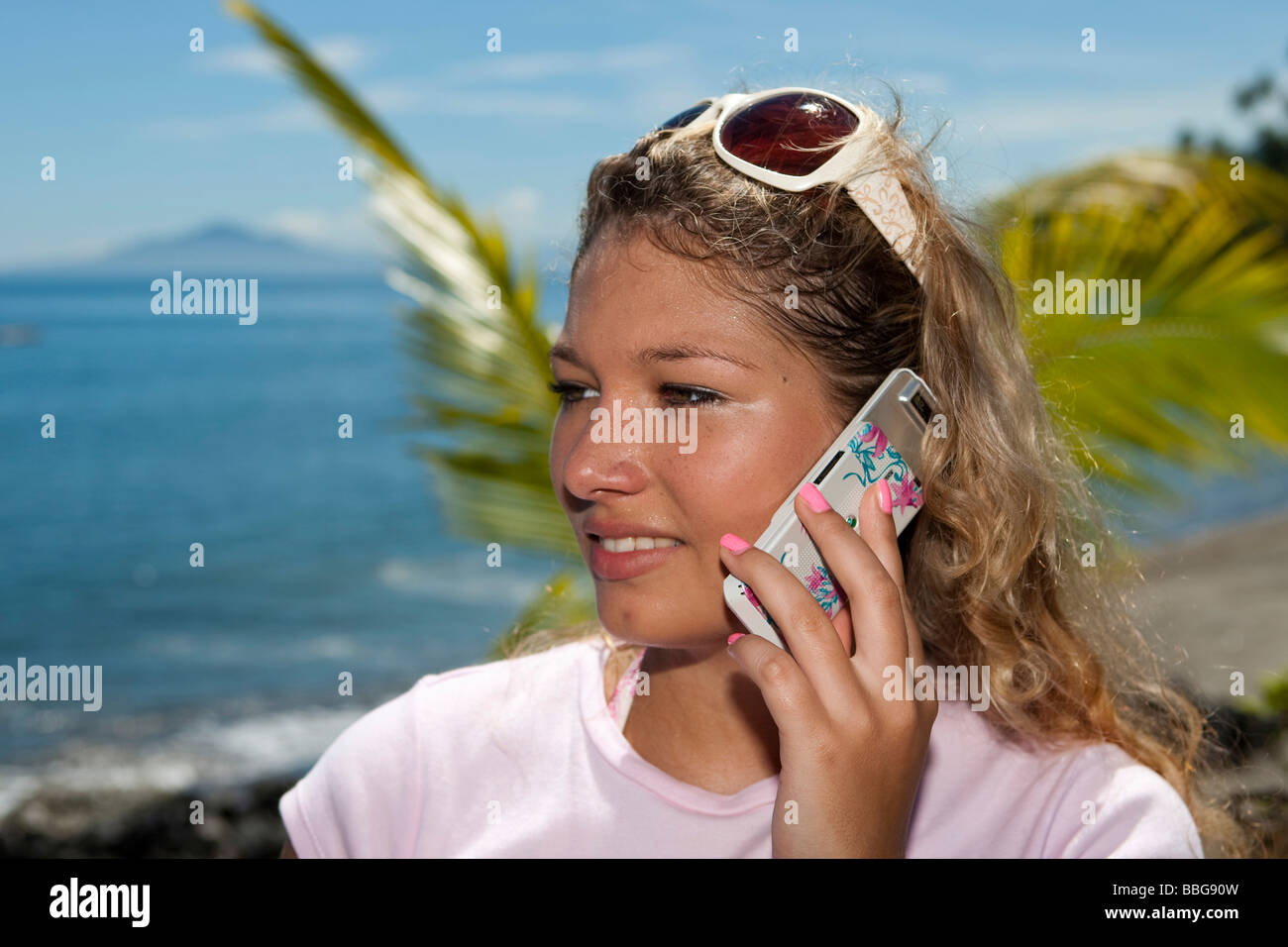 Woman with mobile phone by the pool, Indonesia, Southeast Asia Stock Photo