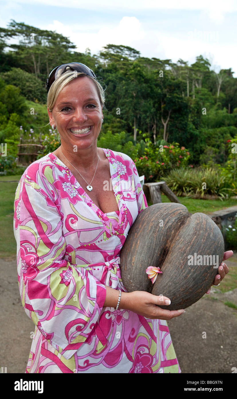 A woman holding a Coco de Mer, Le Jardin Du Roi Spice Garden, Mahe Island, Seychelles, Indian Ocean, Africa Stock Photo