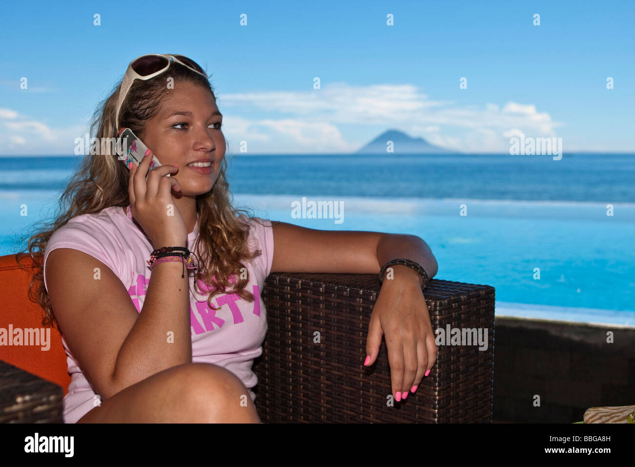 Woman with mobile phone by the pool, Indonesia, Southeast Asia Stock Photo