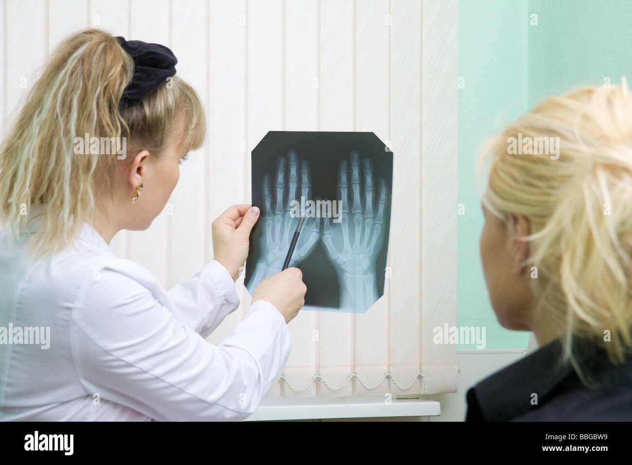 Doctor and patient examine x ray of women hands Stock Photo