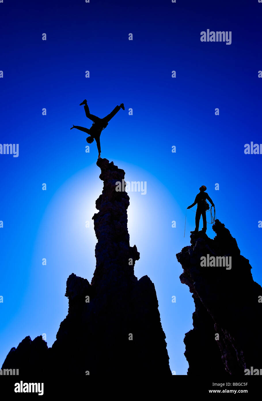 Rock climber celebrates with a handstand on the summit. Stock Photo