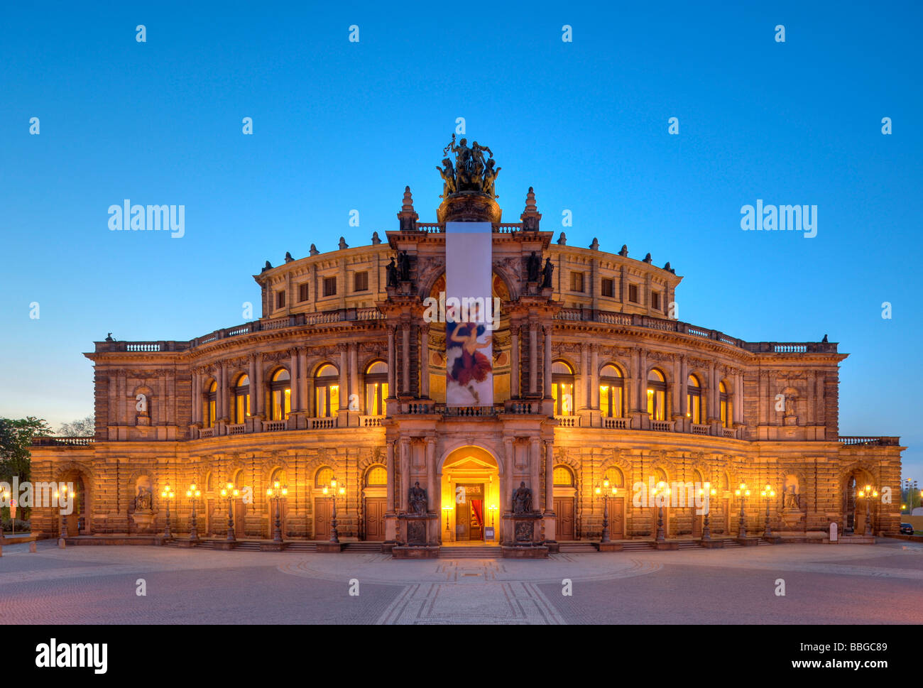 Night shot, illuminated Semperoper opera house with flags, Theaterplatz square, Dresden, Free State of Saxony, Germany, Europe Stock Photo