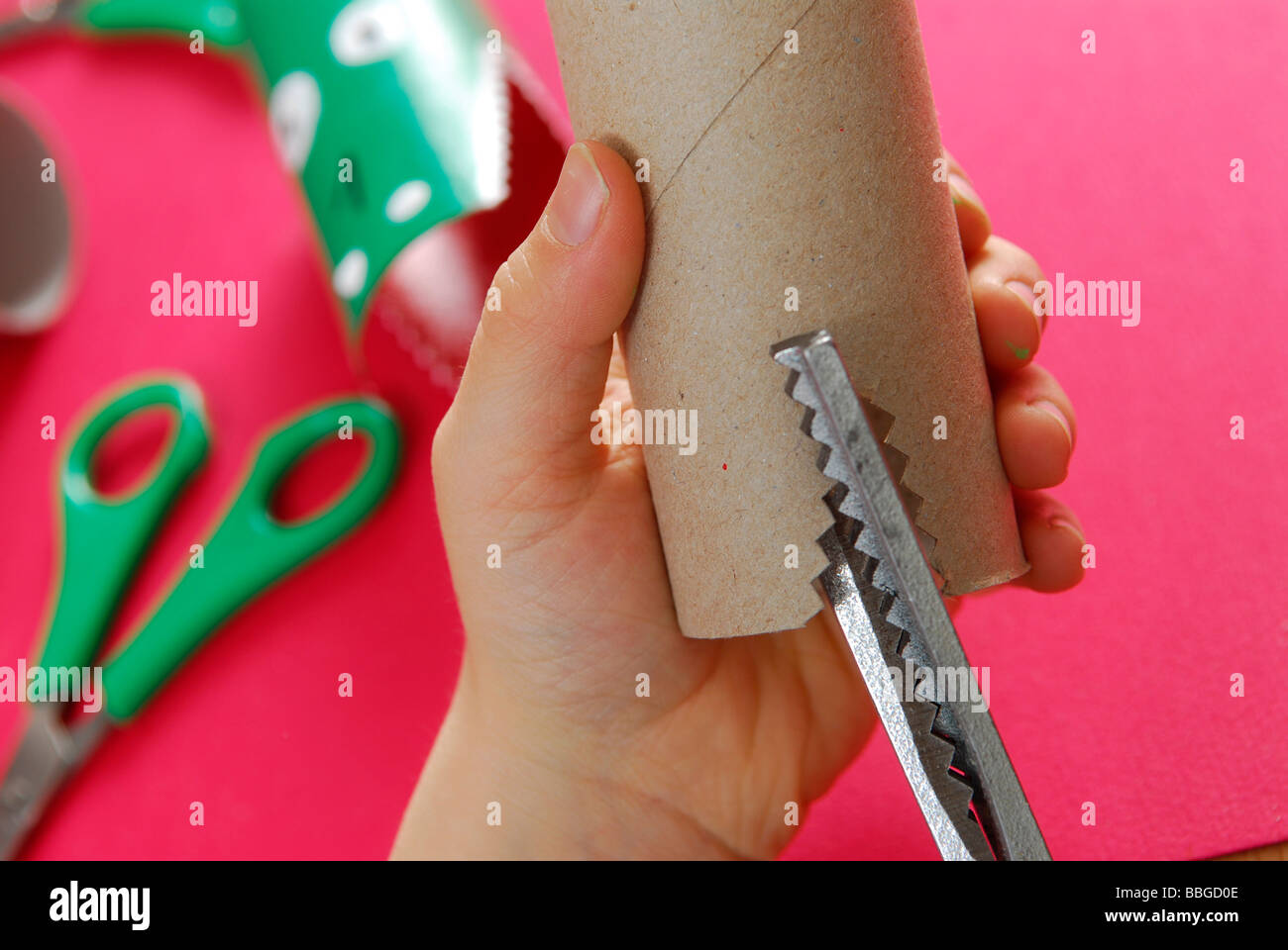 Children's hands cutting with zigzag scissors Stock Photo