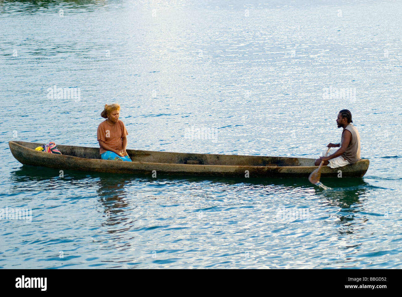 Woman and man in a dugout canoe , Malaita , Solomon Islands Stock Photo