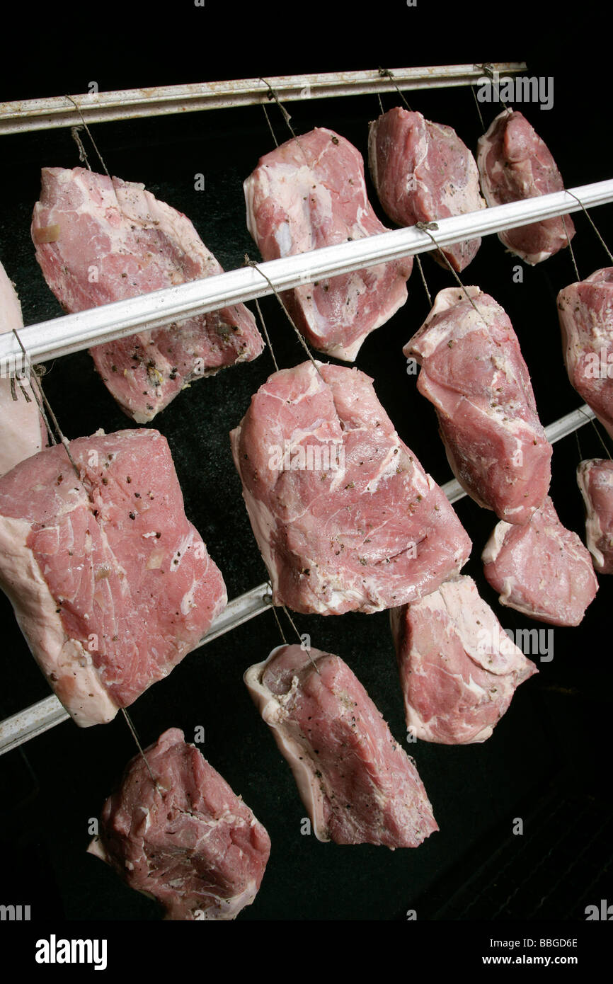 Hanging pork joints in a smoker, production of the bavarian specialty Schwarzgeraeuchertes, smoked ham in a butchery in Hengers Stock Photo