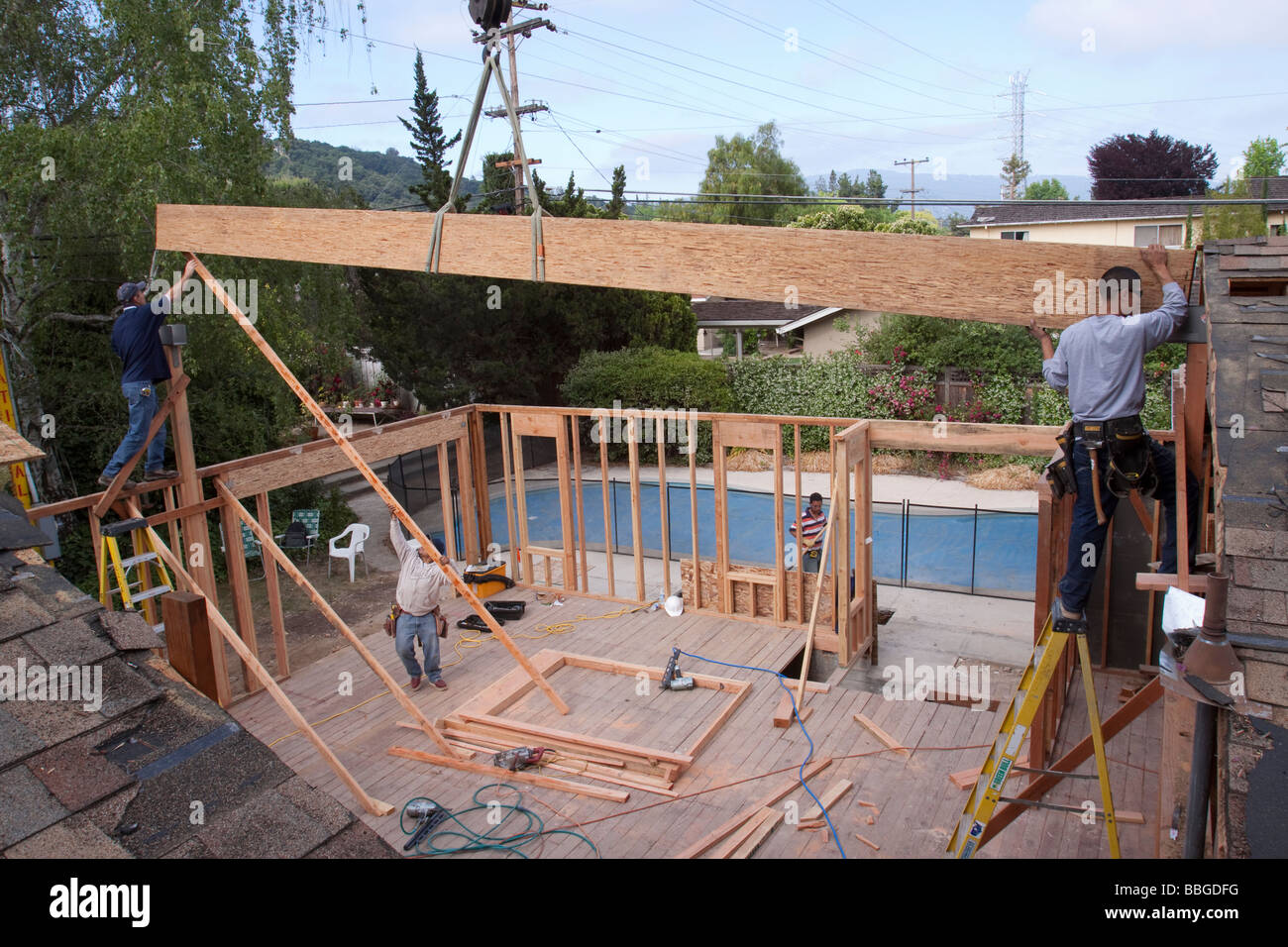 Carpenters Placing A Heavy Ridge Beam Into Brackets As It Is Lowered By A Crane Stock Photo Alamy