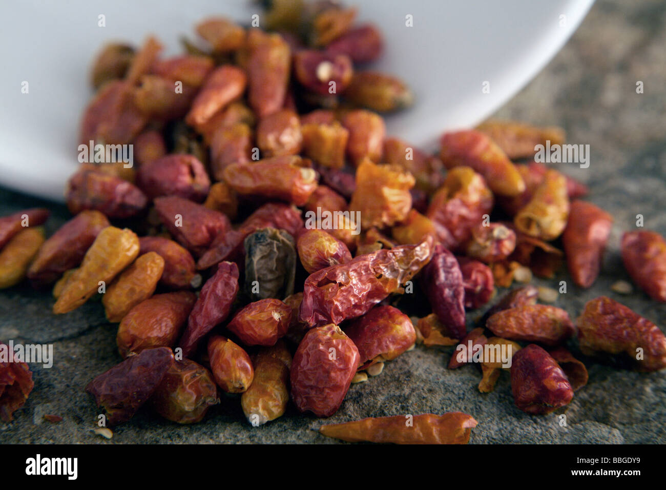 Dried chili peppers tipped from a bowl Stock Photo