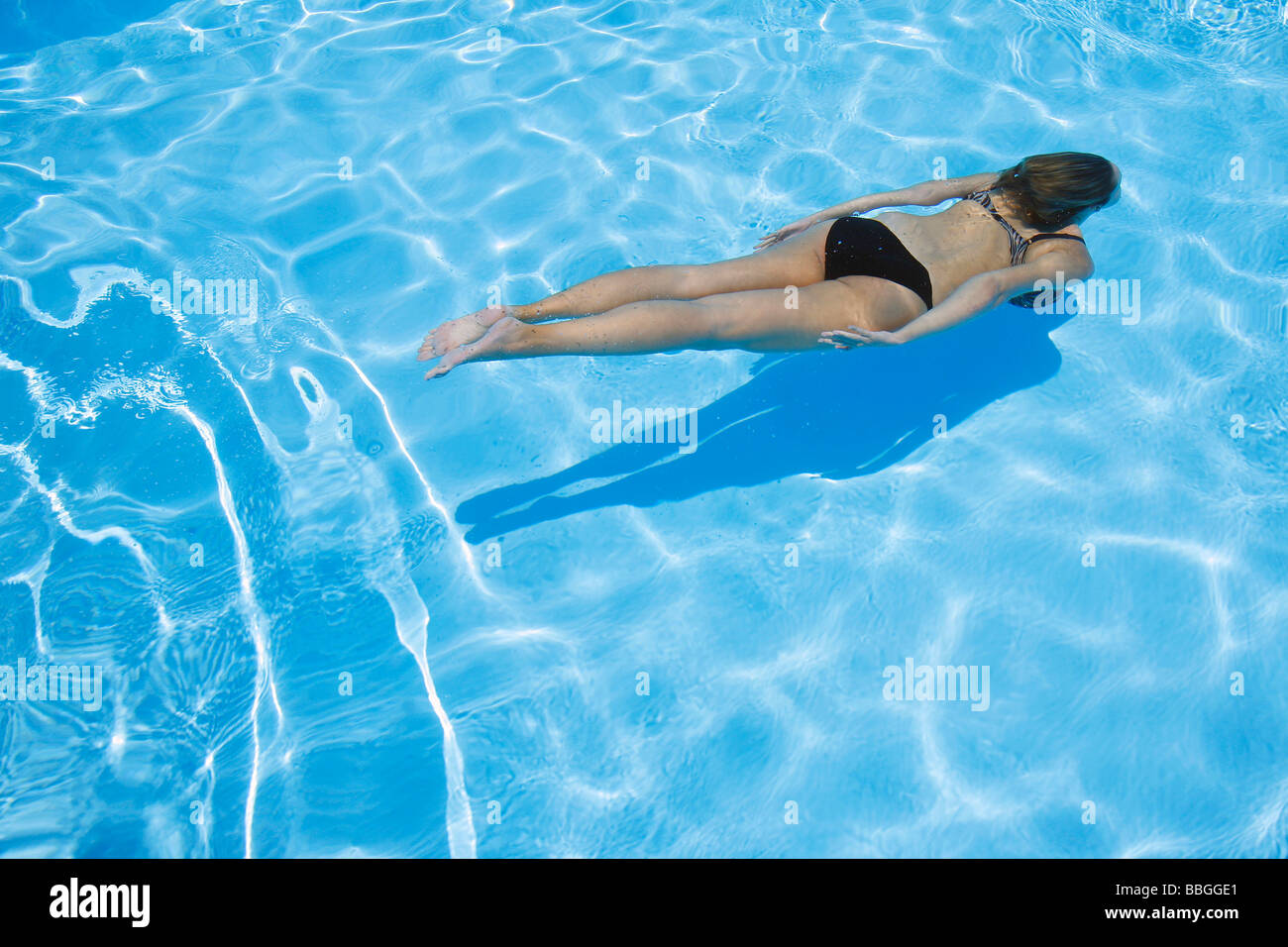 Pretty girl in bikini diving into blue pool Stock Photo - Alamy