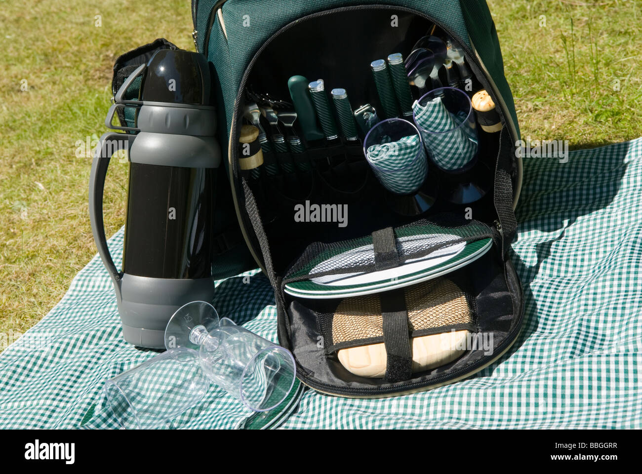 A picnic backpack hamper set outside on a checked green tablecoth England Stock Photo