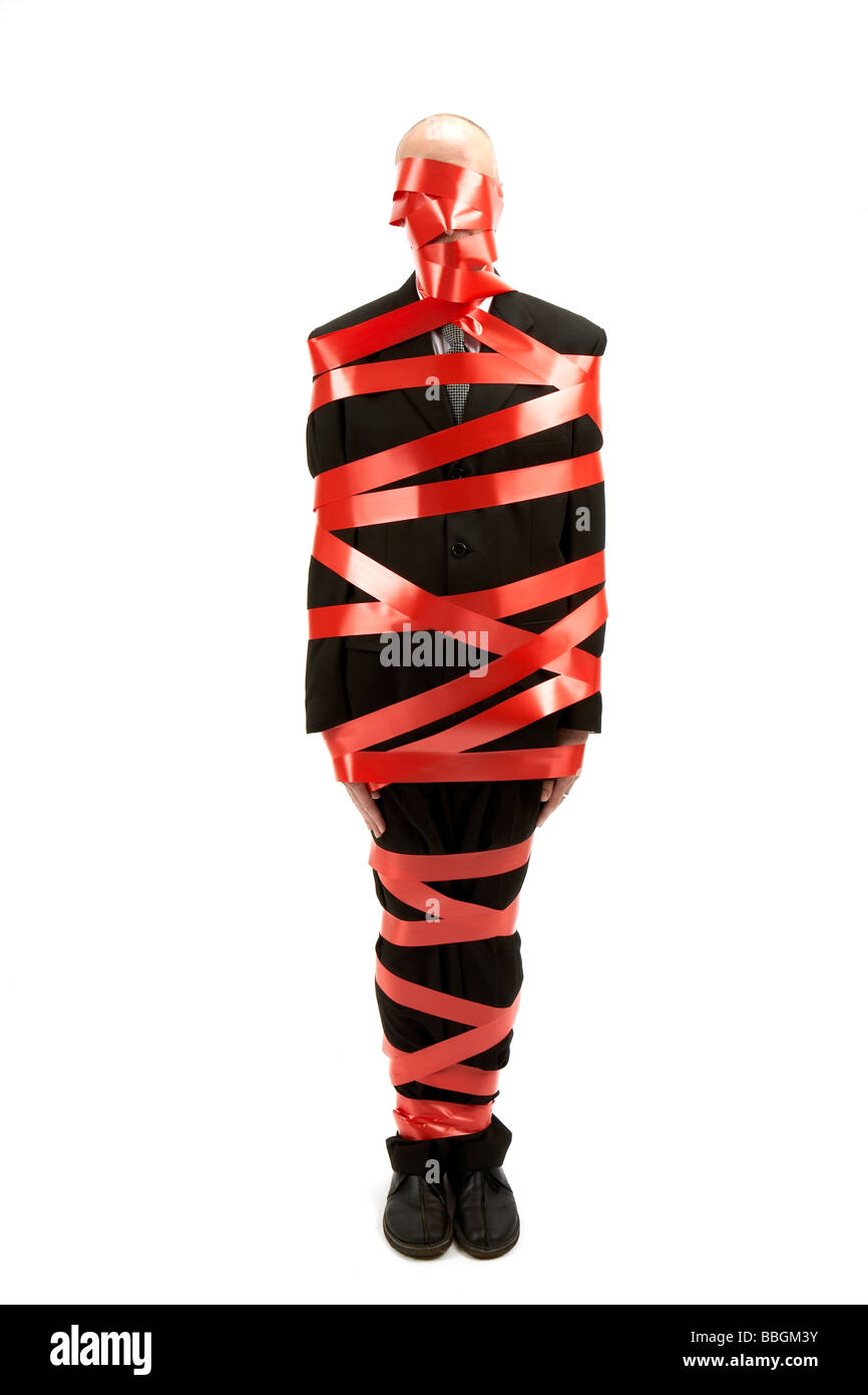 business man wrapped in red tape Stock Photo
