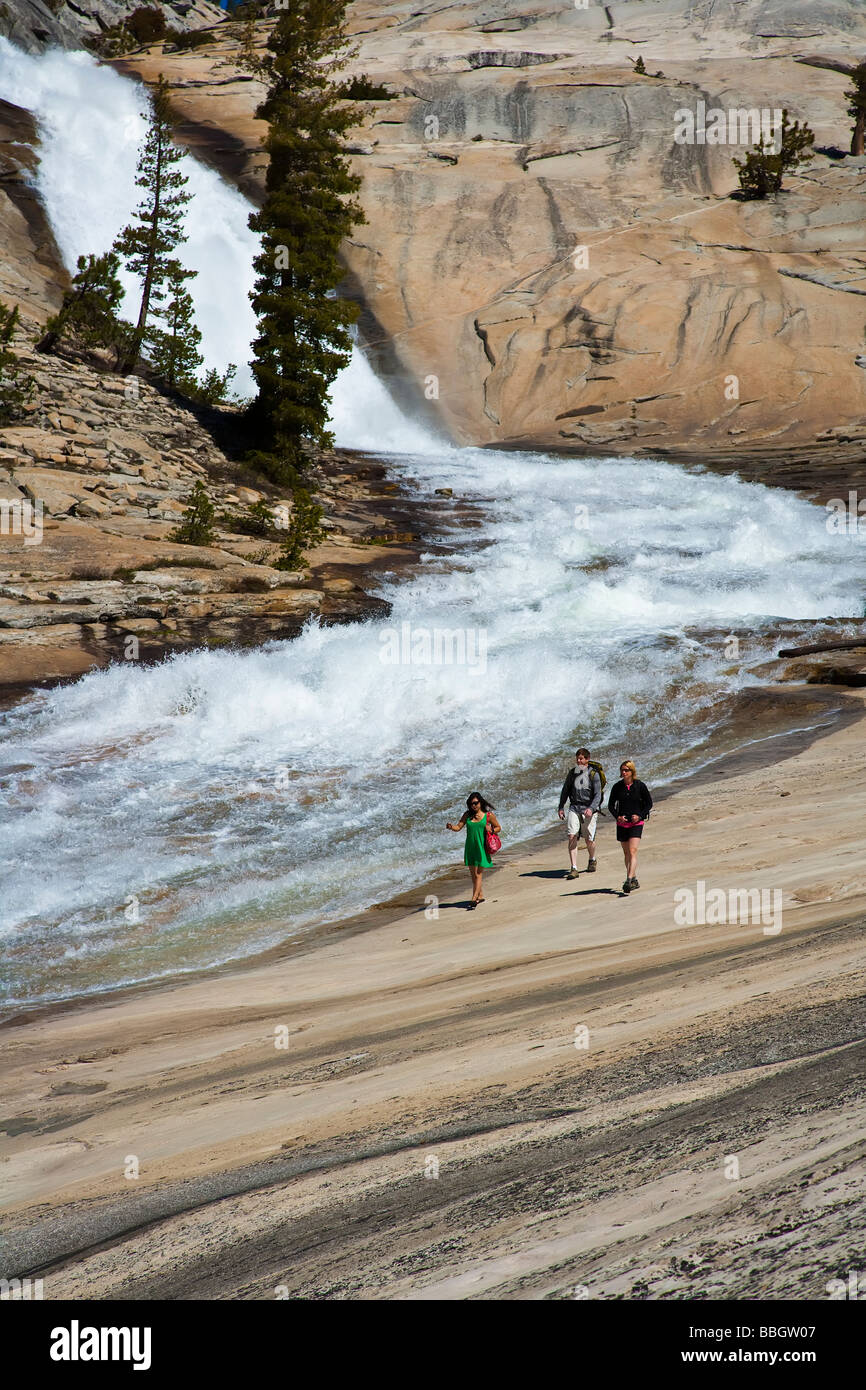 Hikers following a trail along a cascading waterfall Stock Photo - Alamy