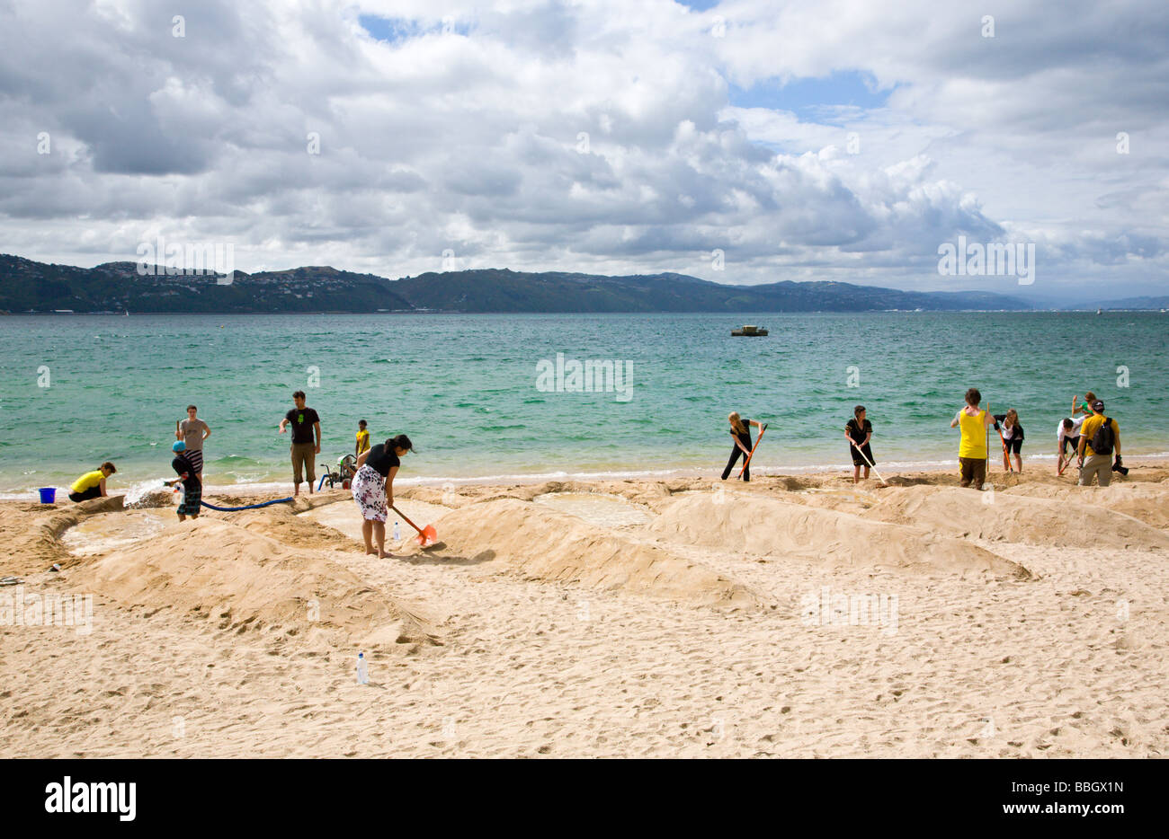 People creating a giant sand sculture of a fern leaf Oriental Beach Wellington New Zealand Stock Photo
