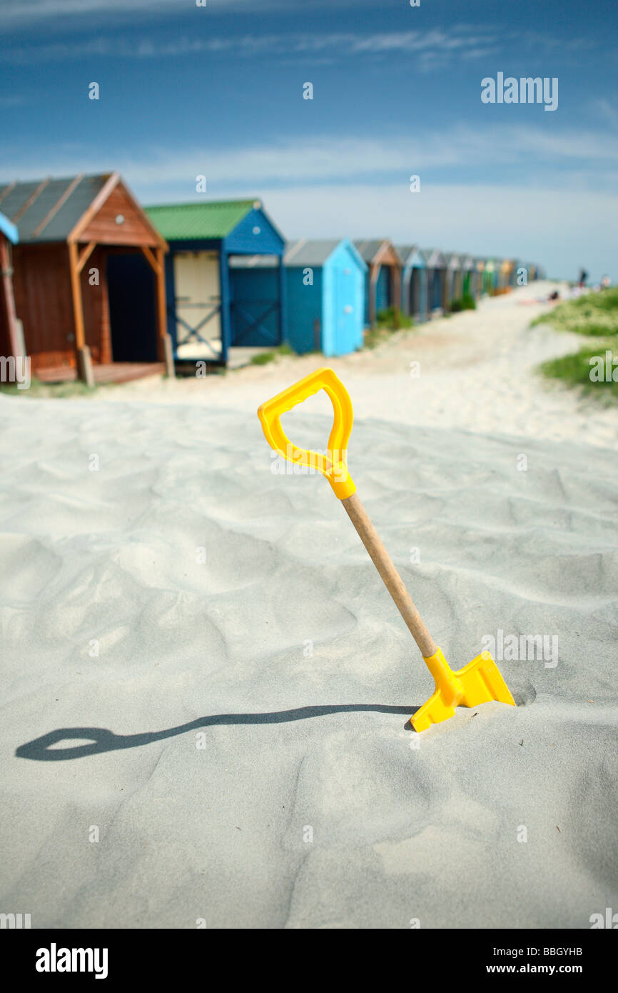 spade in sand by beach huts West Wittering West Sussex England UK Stock Photo