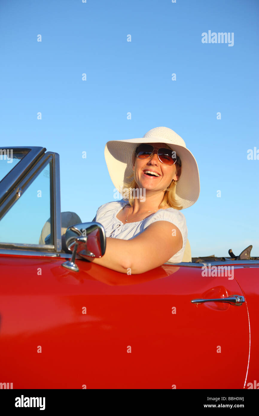 Young woman in red convertible car Stock Photo