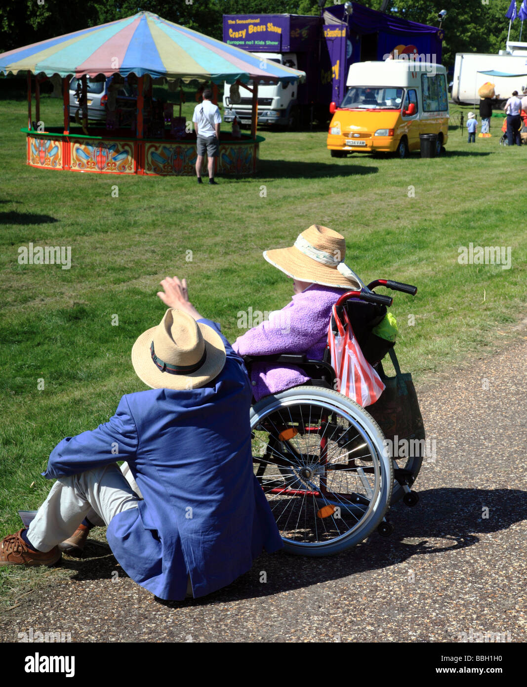 an-elderly-couple-one-in-a-wheelchair-sit-in-the-sun-stock-photo-alamy