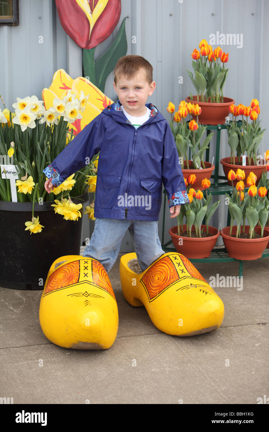 Young boy standing in over sized wooden shoes Stock Photo