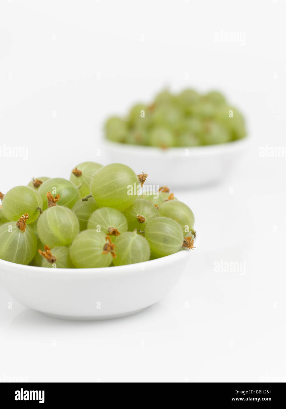 Bowls of gooseberries isolated on white background Stock Photo