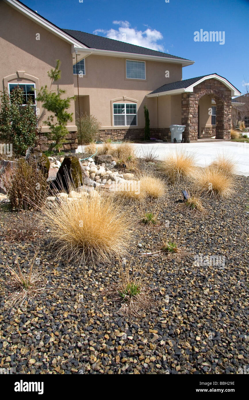 Xeriscaping using rock and native grass to conserve water at a residential home in Boise Idaho USA  Stock Photo