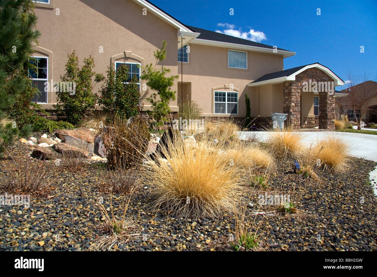 Xeriscaping using rock and native grass to conserve water at a residential home in Boise Idaho USA  Stock Photo