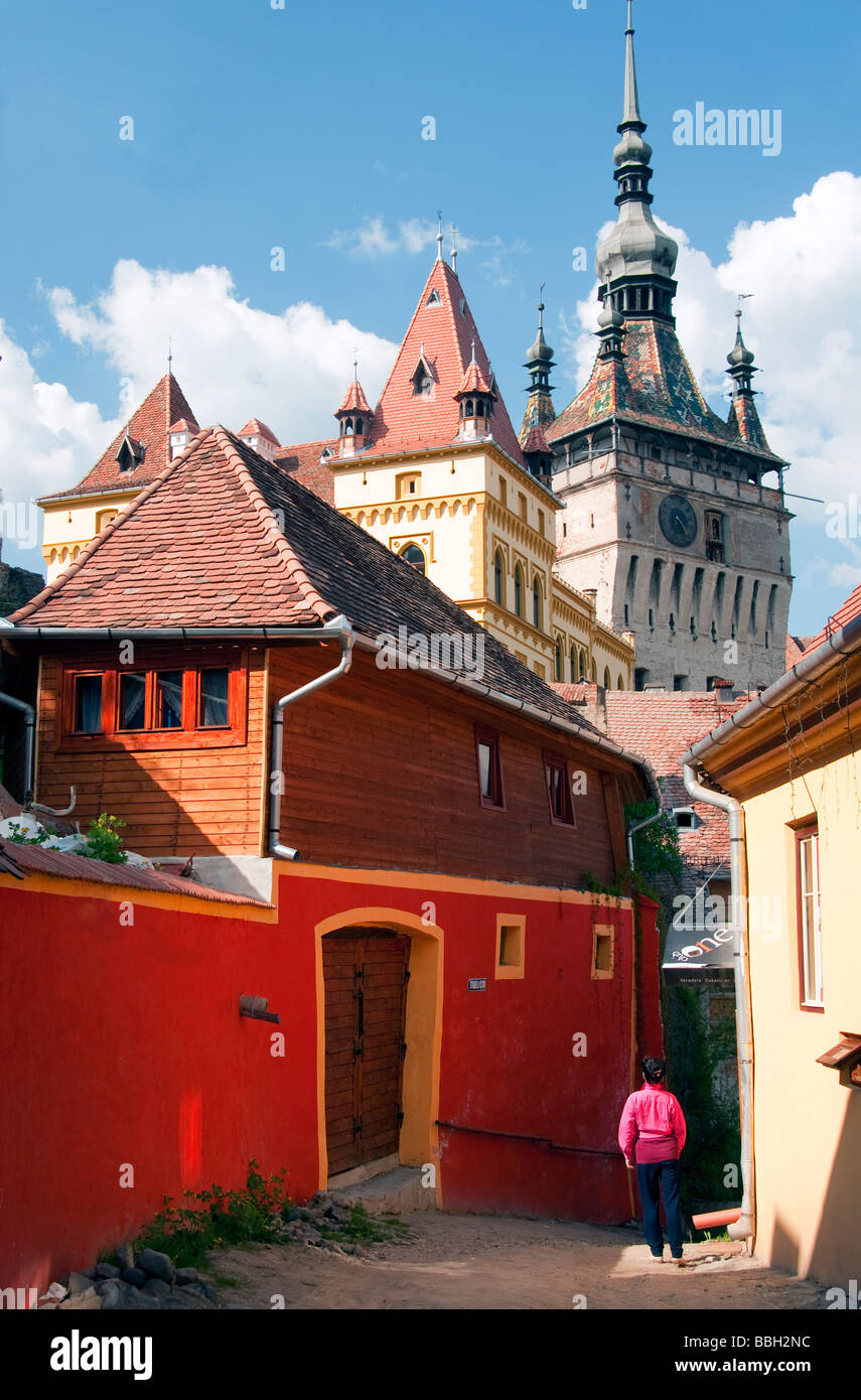 Residential lane in medieval citadel town of Sighisoara (Schassburg in German) with clock tower above Stock Photo