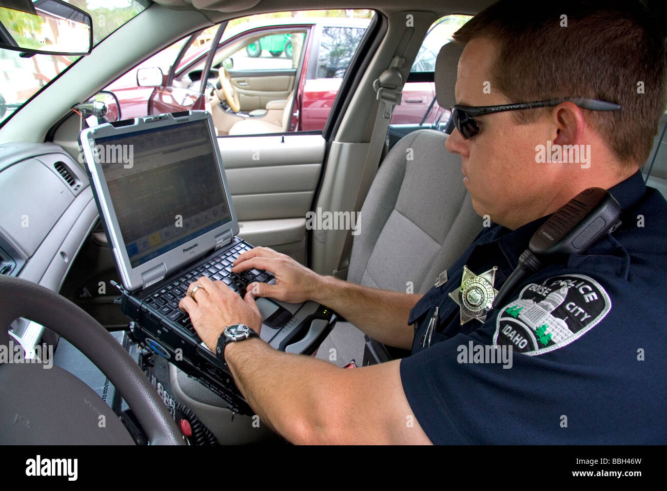 Police officer using a mobile data terminal computer ...