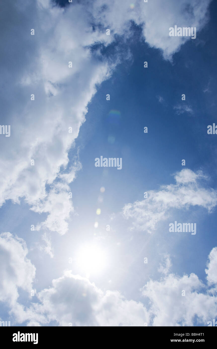 Looking at sun during the day against a blue and cloudy sky Stock Photo