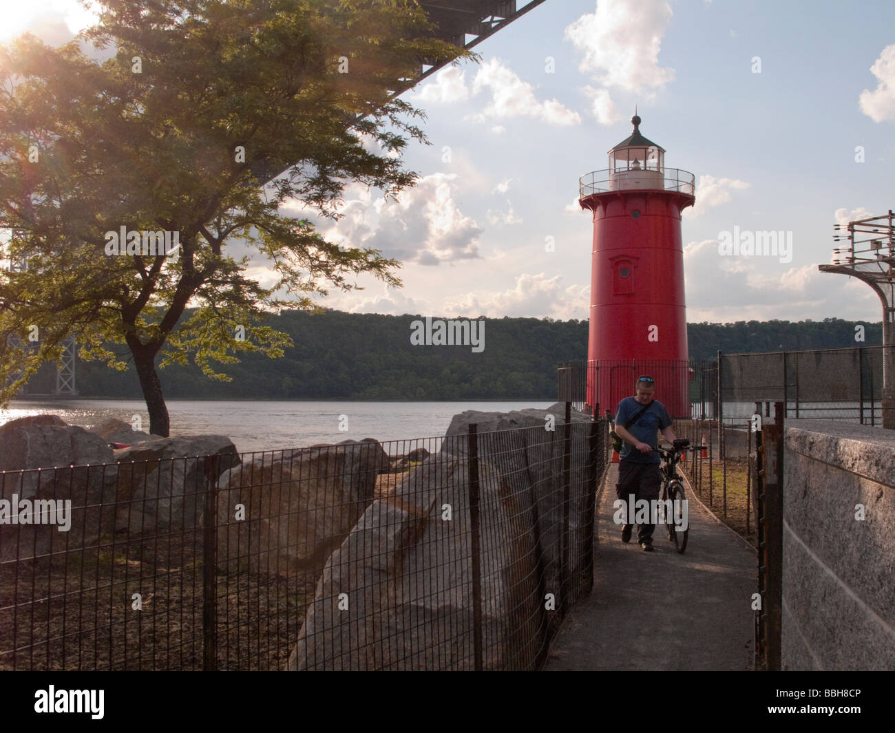 Jeffrey s Hook New York A cyclist walks his bike on the new path that leads to the Little Red Lighthouse Stock Photo